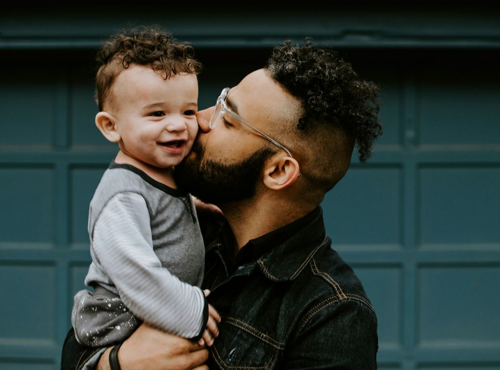 a parent kisses his son on the cheek