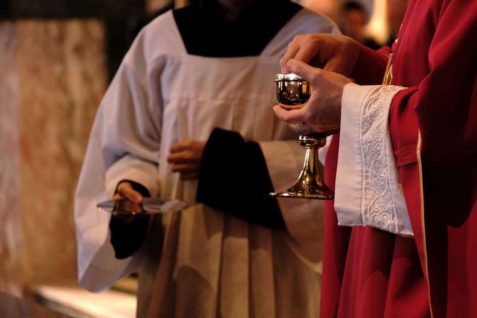 A priest holding a chalice in a church