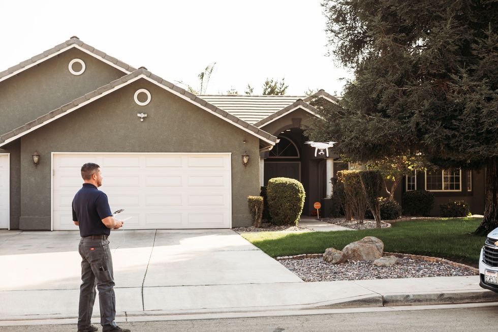 home inspector performing a drone inspection a a house