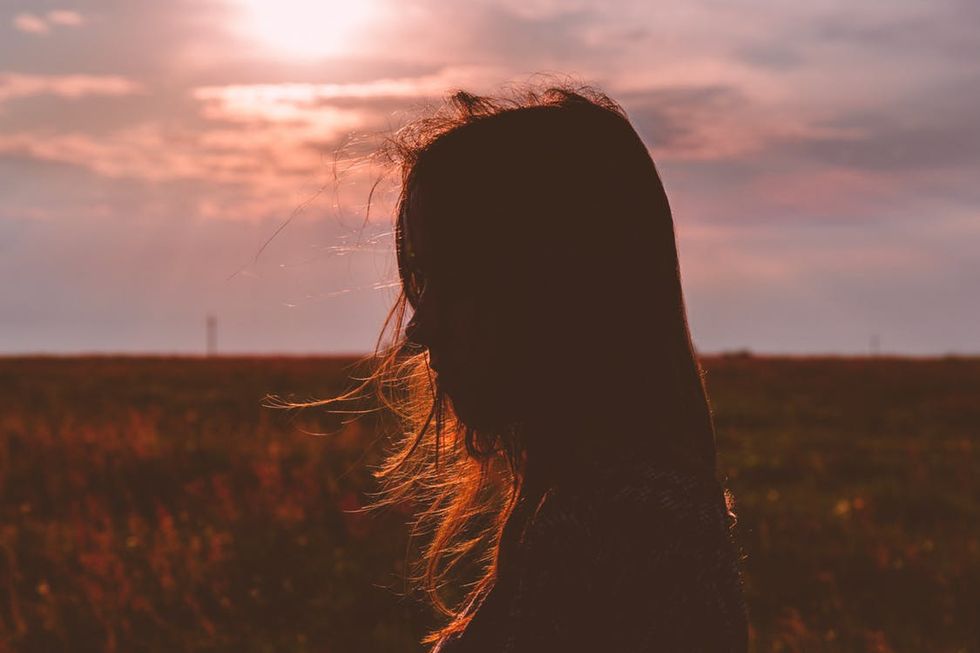 woman reflecting about her faith in a field